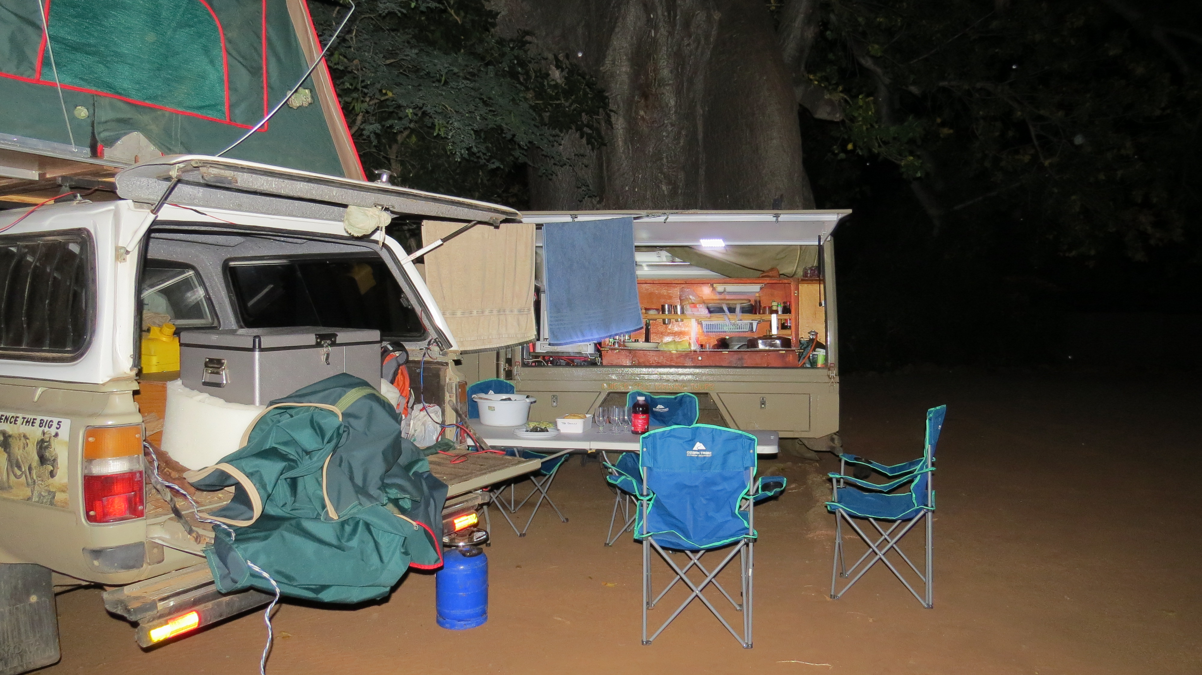 4x4 vehicle with kitchen canopy open at a bush camp at night in Kruger