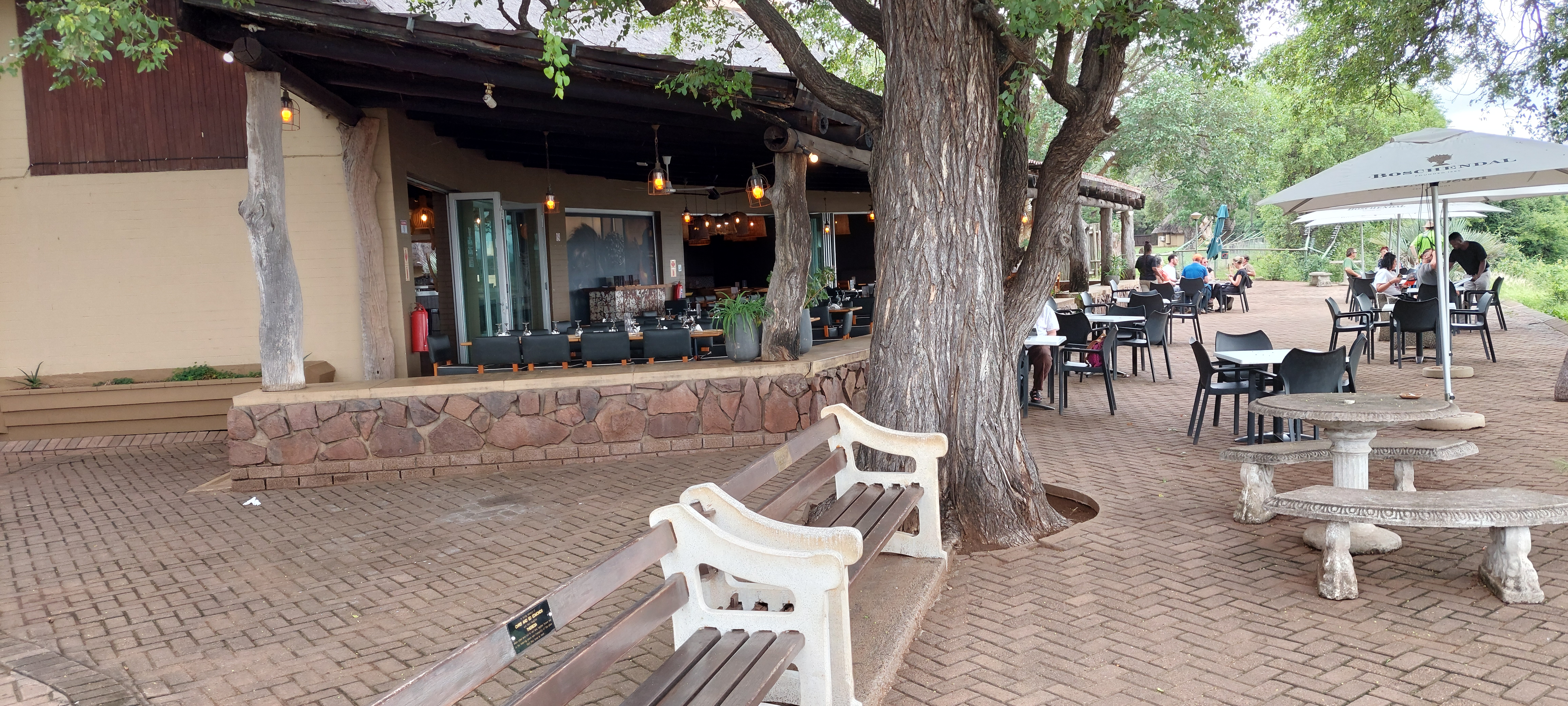 Outdoor tables and trees at a Kruger National Park camp restaurant